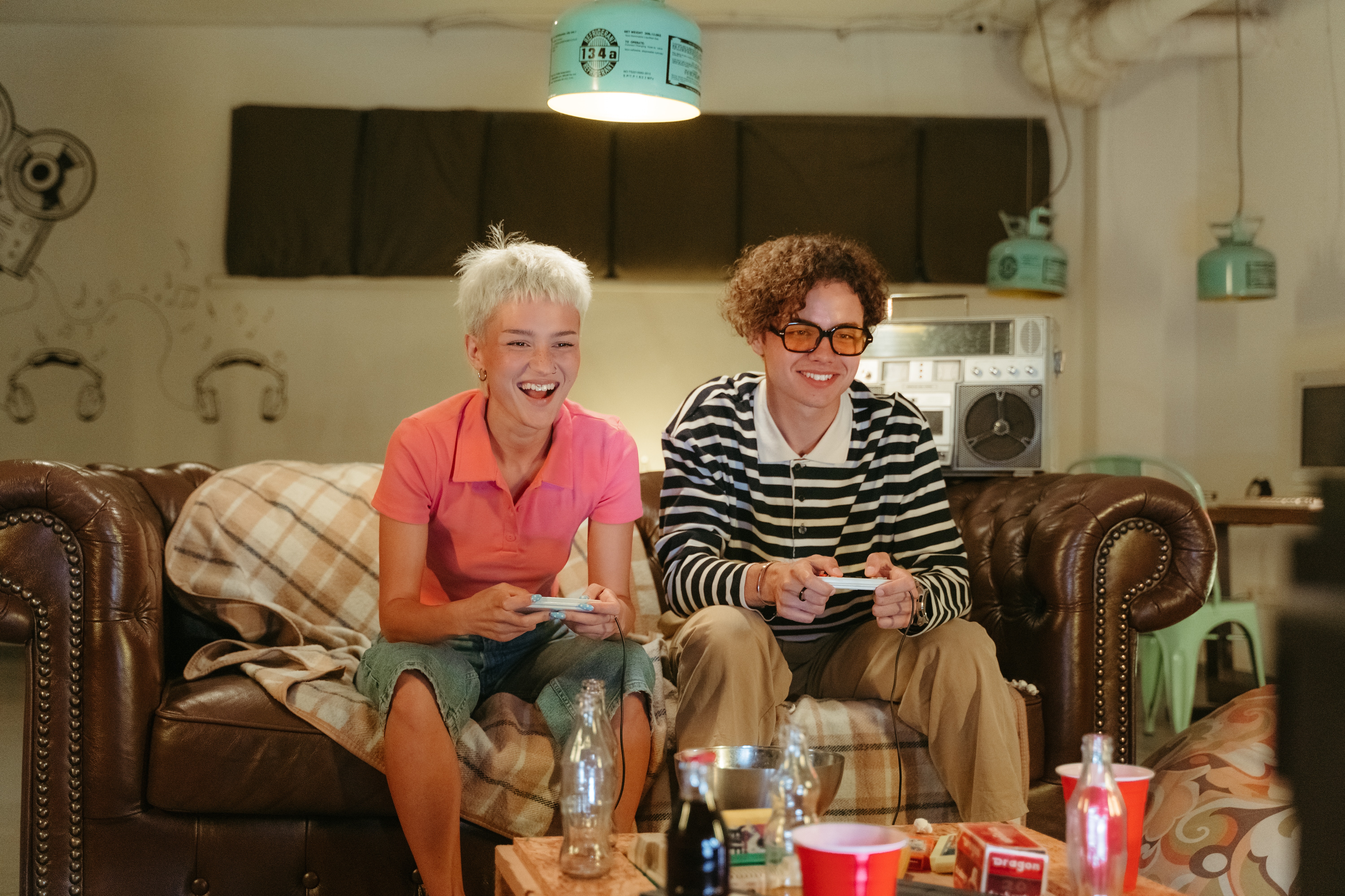 Two teens playing video games on couch