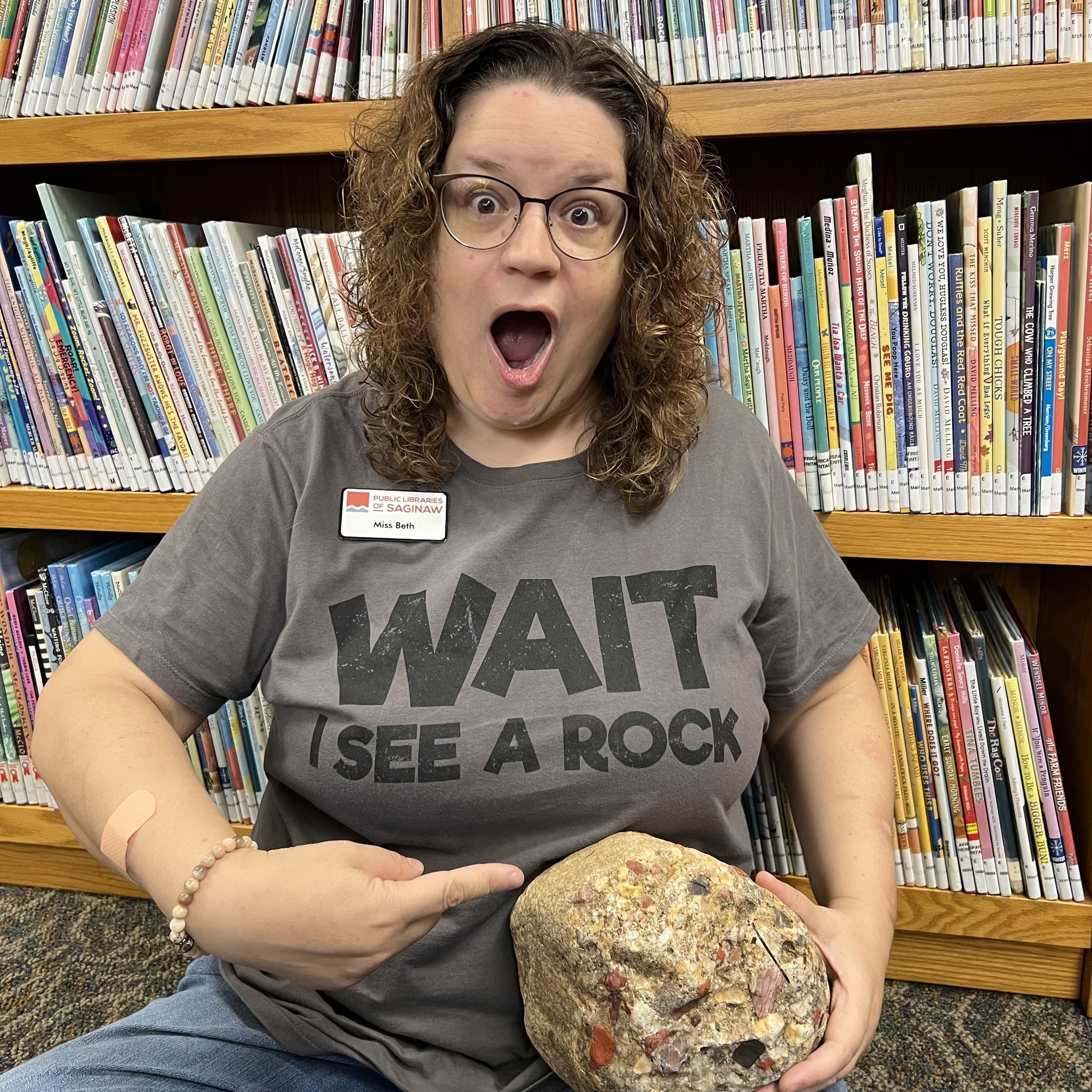 Miss Beth points to a giant pudding stone with an expression of wonder