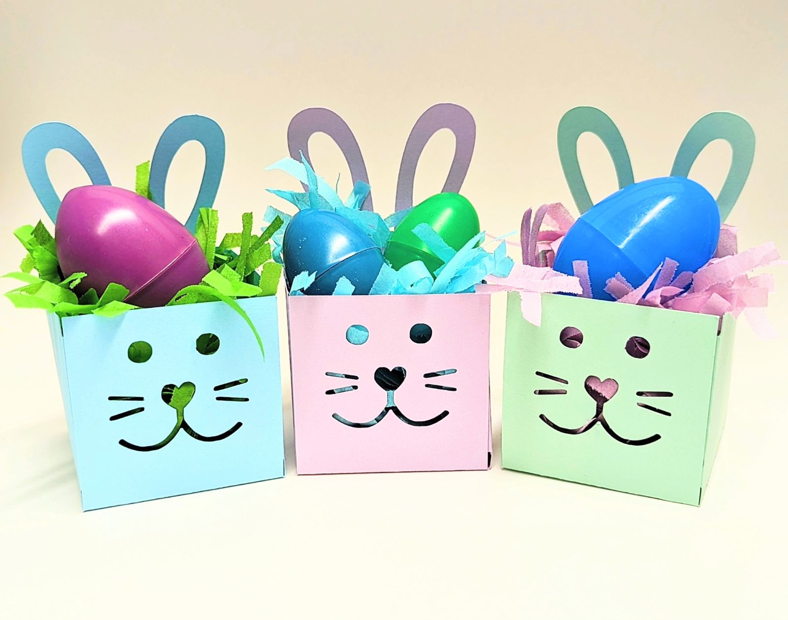 Bunny shaped boxes made out of pastel colored cardstock with a plastic egg inside.