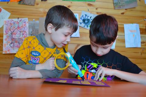Boys using a 3D pen