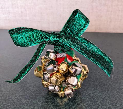 Jingle bell ornament made with a ribbon bow on top.