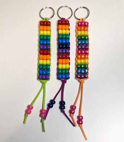 3 rainbow keychains made with colorful pony beads on leather cord.