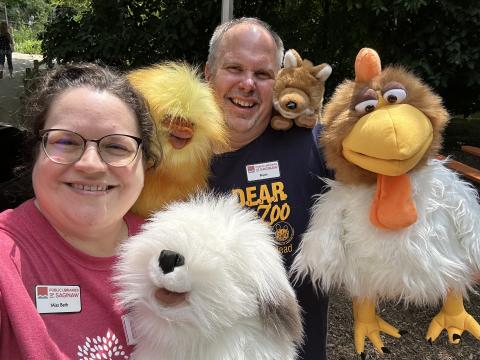 PLOS library assistants Miss Beth and Bryan hold some puppets