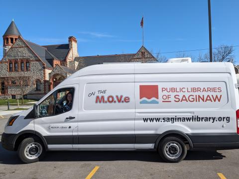 Outreach Library Assistant Beth Lasky waves from the Public Libraries of Saginaw's Bookmobile