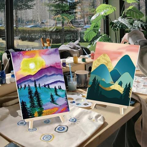 two paintings of mountains on easels