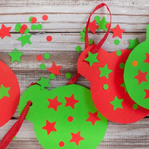Green and red paper ornaments with stars on a red ribbon