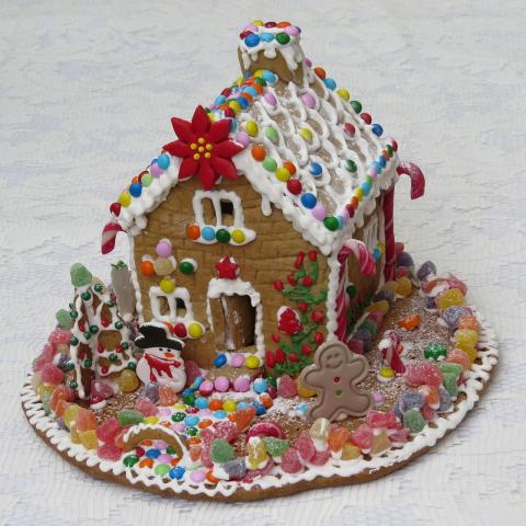 A picture of a gingerbread house is shown with frosting and candy decorations.