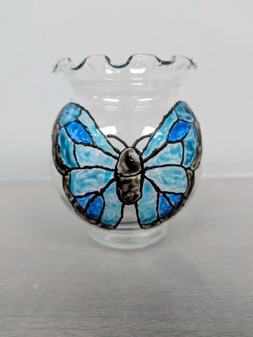 Clear glass bowl with a butterfly painted on it in shades of blues and black.