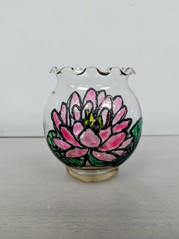 Clear glass bowl with a painted pink lotus sitting on two green lily pads.