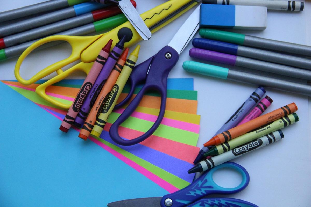 Craft supplies are shown, including scissors, paper, markers, and crayons.