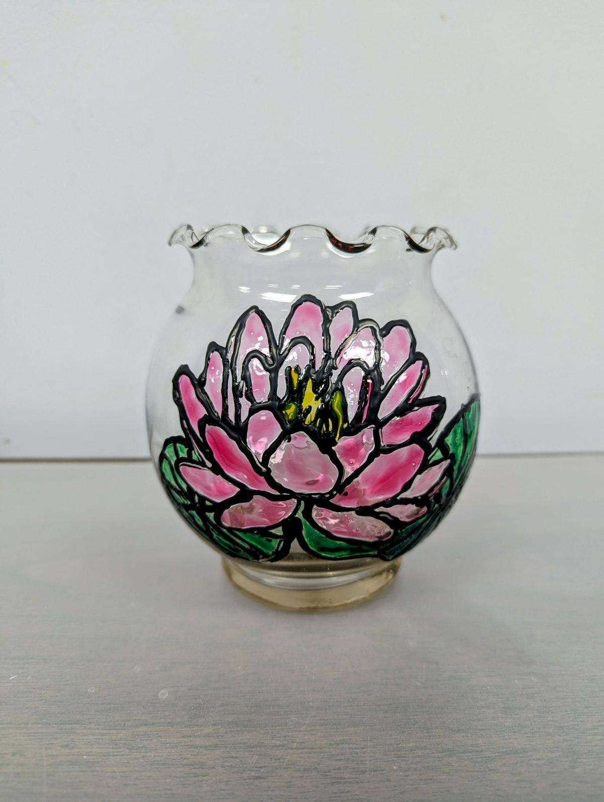 Clear glass bowl with a painted pink lotus sitting on two green lily pads.